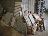 a pile of old toilets in a garage next to a pile of other toilets
