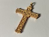 a close up of a gold cross on a white surface