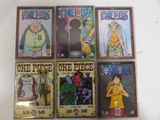 six one piece comics are on display on a white surface