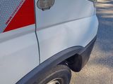 a white van with a red stripe parked on the side of the road