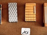 four different types of lighters are lined up on a brown surface
