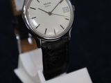 une montre posée sur un socle, sur une surface noire