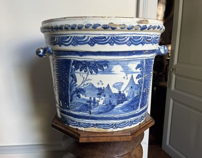 un grand vase bleu et blanc posé sur un socle en bois