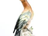une figurine d'oiseau assis sur une branche