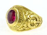 a close up of a gold ring with a red stone in it