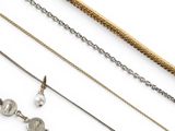 several different types of necklaces and chains on a white surface