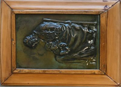 une photo d'une plaque en bronze dans un cadre en bois