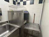 un évier en inox dans une cuisine aux murs à carreaux