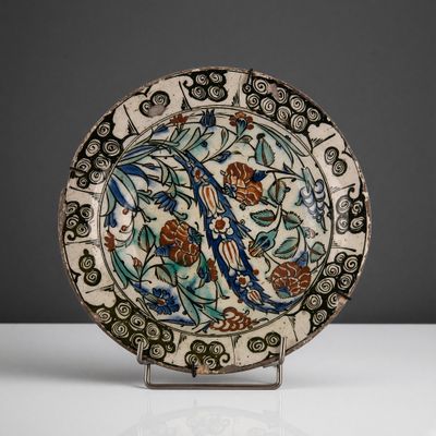 a decorative plate with a bird and flowers on it