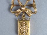 an image of a gold plated brooch with a bow on it
