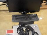 a desk with a monitor, keyboard, headphones and a mouse on it