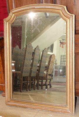 un grand miroir posé par terre à côté d'une chaise