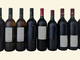 six bottles of wine are lined up in a row on a table