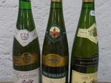 trois bouteilles de vin posées sur une table, l'une à côté de l'autre