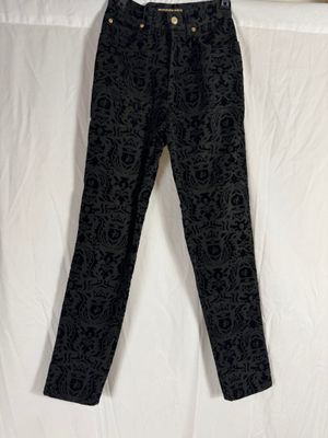 un pantalon à motif cachemire noir et blanc suspendu à un portant