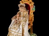 an image of a figurine of a woman in a white dress sitting on a gold throne