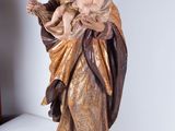 statue of jesus holding a child in his arms on a table