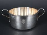 an old silver pot with handles on a black background