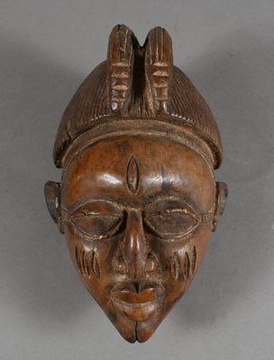 an image of a wooden mask hanging on a wall