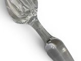 a glass spoon with a metal handle on a white surface