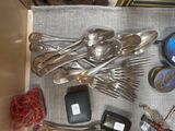 beaucoup de cuillères en argent et de cuillères à soupe sur une table
