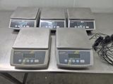 quatre balances électroniques posées sur une table dans une pièce