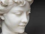 marble bust of a woman with a flowered head on a black background