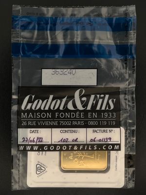 le lingot d'or se trouve dans un sac en plastique posé sur une surface noire