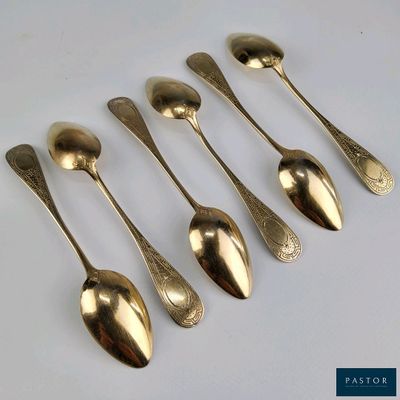 six cuillères sont alignées sur une surface blanche