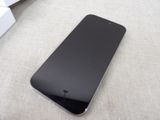 a black cell phone sitting on the floor next to a box