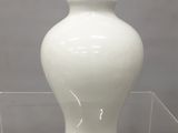un vase blanc exposé dans une vitrine