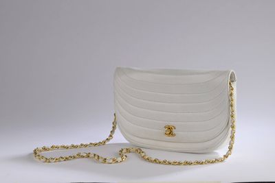 a white purse with a gold chain hanging from it