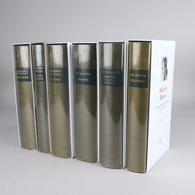 four books in a row sitting on a table next to a box