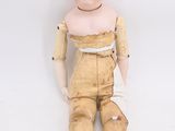 a doll that is sitting on the ground with a bandage on it ' s leg