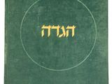 un vieux livre vert avec des inscriptions en hébreu sur la couverture