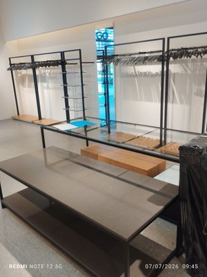 an image of a clothing store with clothes hanging on racks