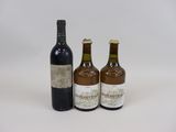 trois bouteilles de vin posées les unes à côté des autres sur une surface blanche