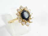 an image of a gold ring with a blue stone surrounded by white diamonds