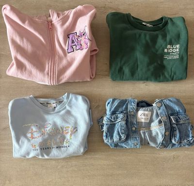 trois paires de vêtements pour bébé disposées sur un parquet