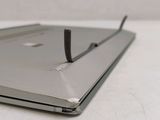 a laptop with a nail stuck to the side of it
