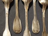five spoons that are sitting next to each other on a table