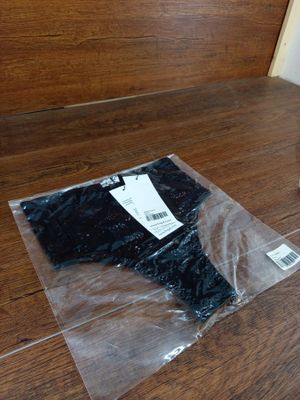 un sac en plastique posé par terre à côté d'un pantalon noir