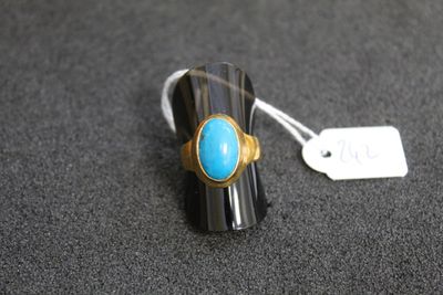 un gros plan d'une bague sertie d'une pierre turquoise