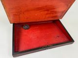 a wooden box with a red lid on a white surface