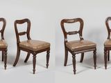 quatre chaises sont alignées en rangée sur une surface blanche