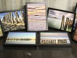 six photos encadrées représentant une scène de plage, posées sur une table