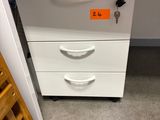 a white filing cabinet with a key on top of it