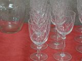six wine glasses and a decanter on a table