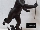 statue d'un petit garçon tenant un bâton et debout sur un rocher