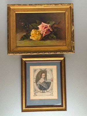 two framed pictures of flowers hang on a wall in a room